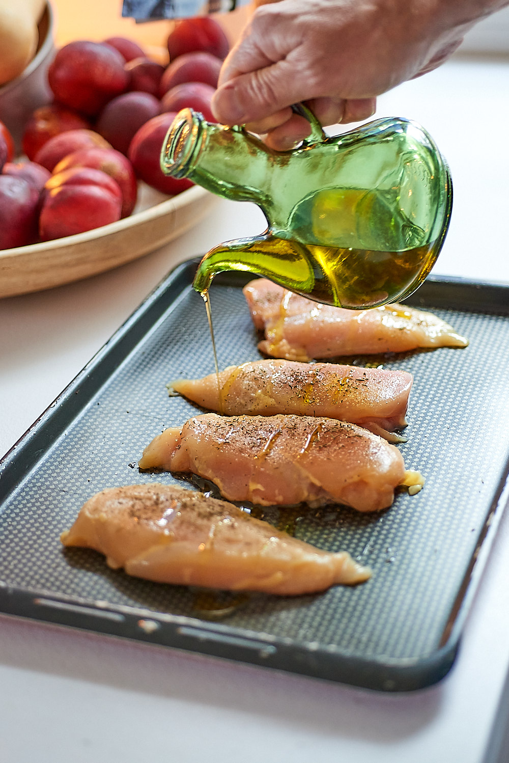 photo de Verser un filet d'huile d'olive sur les filets de poulet
